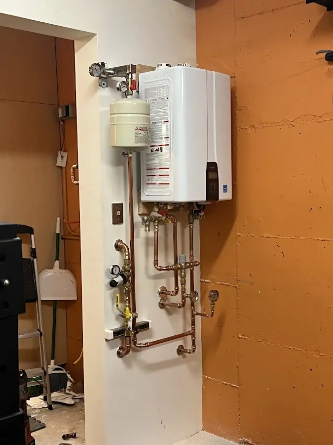 Plumbing technician inspecting water heater connections in Sunland Park